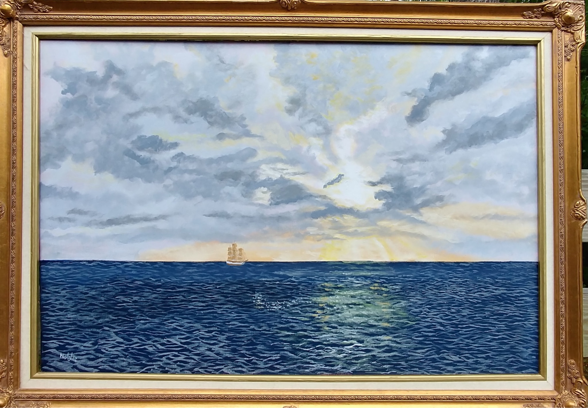 Sunset At Sea, a sailing ship beneath a luminous sky in a gold frame